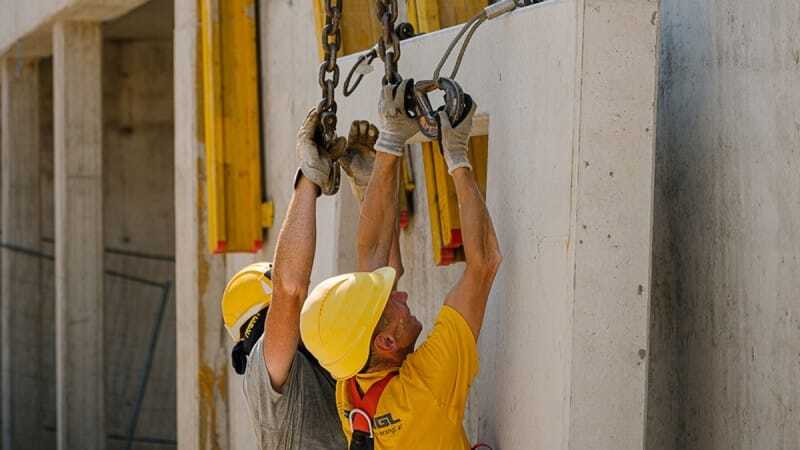 Two construction workers fix a concrete slab